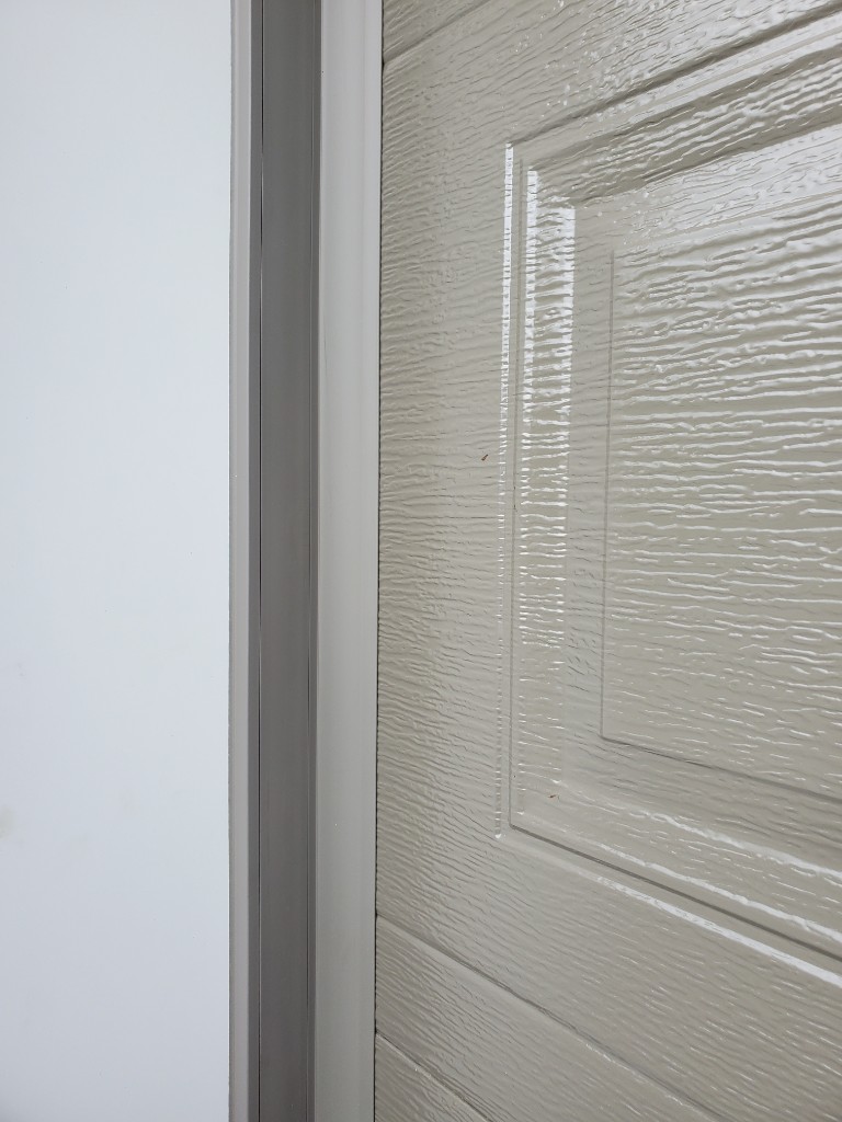 PVC jamb weatherstrip seal along a garage door edge — Ottawa winter prep