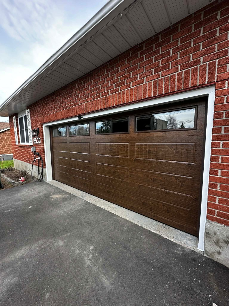 Wood-grain double garage door installed on a brick Ottawa home